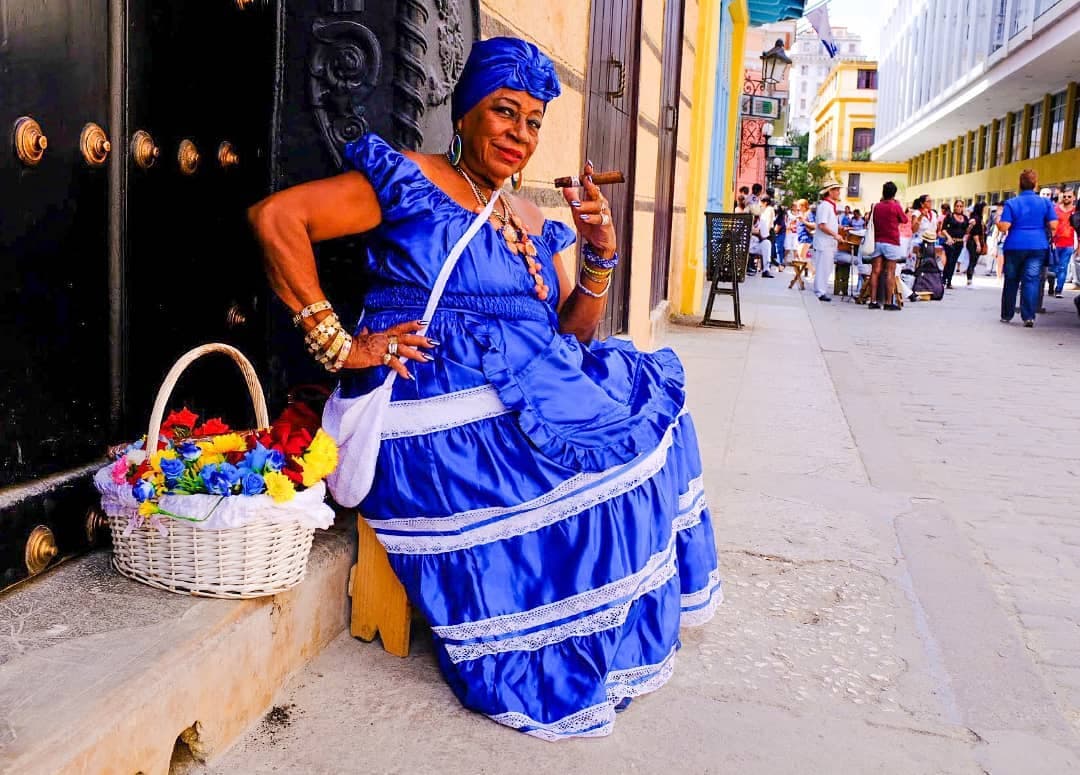 A woman in a blue dress in a colourful street