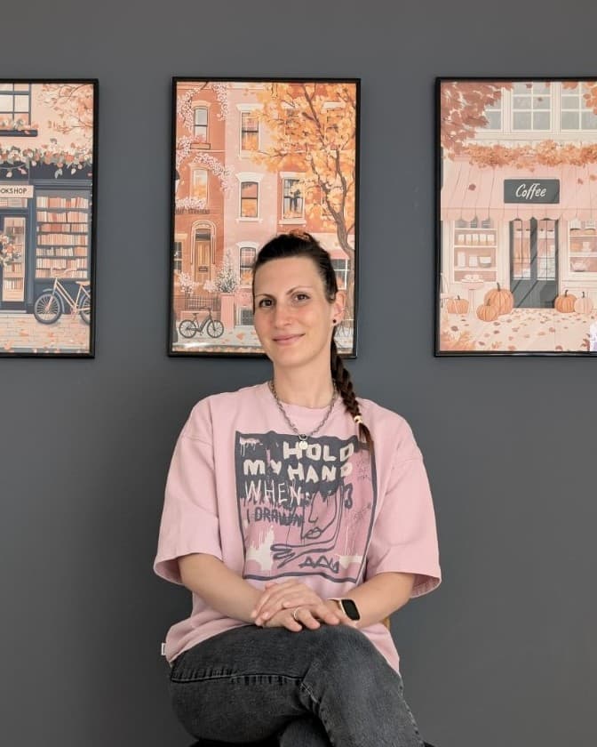 Sofija Hotomski, sitting in front of three framed autumn prints